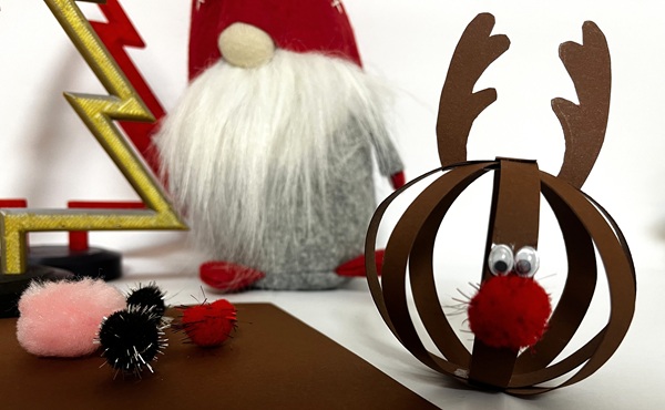 Julpyssel med papptallrikar, handgjorda figurer föreställande en snögubbe och renen Rudolf, dekorerade med färgat papper, röd pompom och googlyögon.